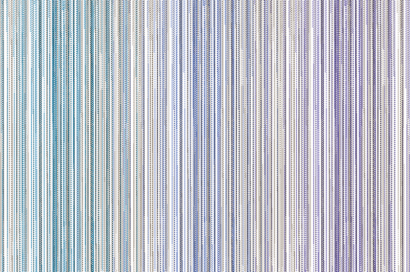 Prostokątny dywan pokryty liniami tworzonymi przez drobne punkty. W odcieniach niebieskiego, fioletu i szarości.